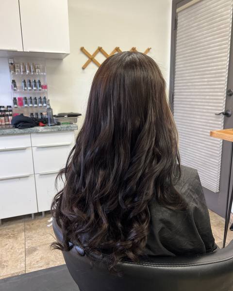 After: the same client with long, full, dark brunette waves from a weft install